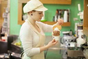 Woman making cup of ice cream.