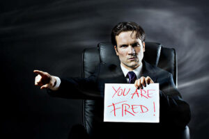 Boss-holding-up-a-sheet-of-paper-with -lettering-"You-are-fired!".