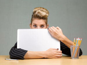 Female-employee-hiding-behind-a-piece-of-paper.