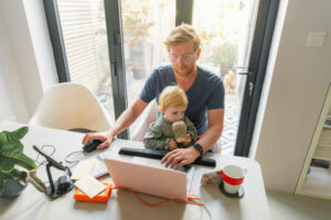 Employee-with-a-baby-on-his-lap-working-from-home.-What-Does-it-Mean-to-Disconnect-from-Work.