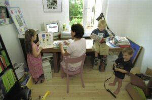 Female-employee-in-a-office-with-three-small-children.