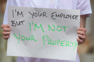 I'm-your-employee-but-i'm-not-your-property-sign-being-held-by-a-employee.