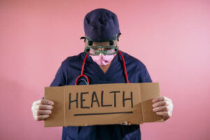 Doctor-holding-a-sign-up-high-that-says-health.-Your-health-and-well-being-matters.